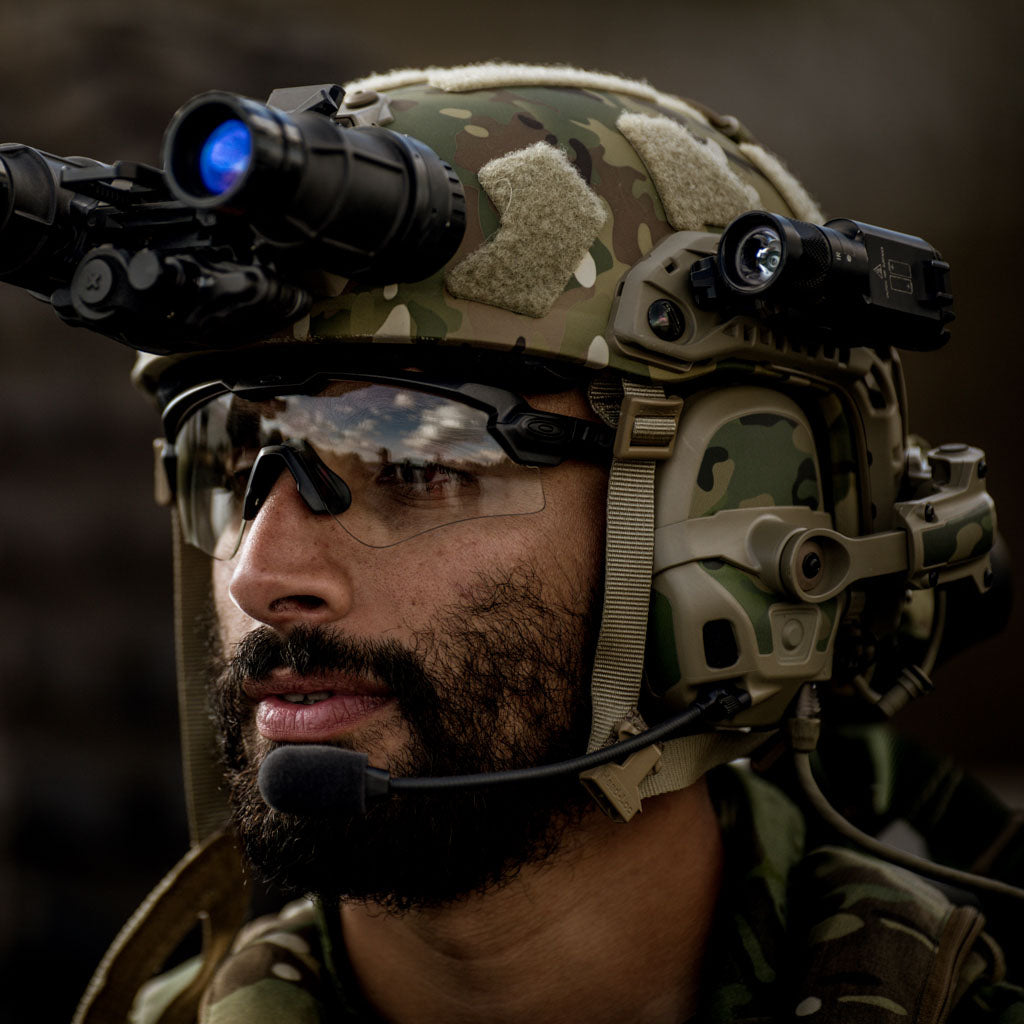 Person wearing a military helmet with camouflage pattern, night vision goggles, and a Thyrm VariArc.