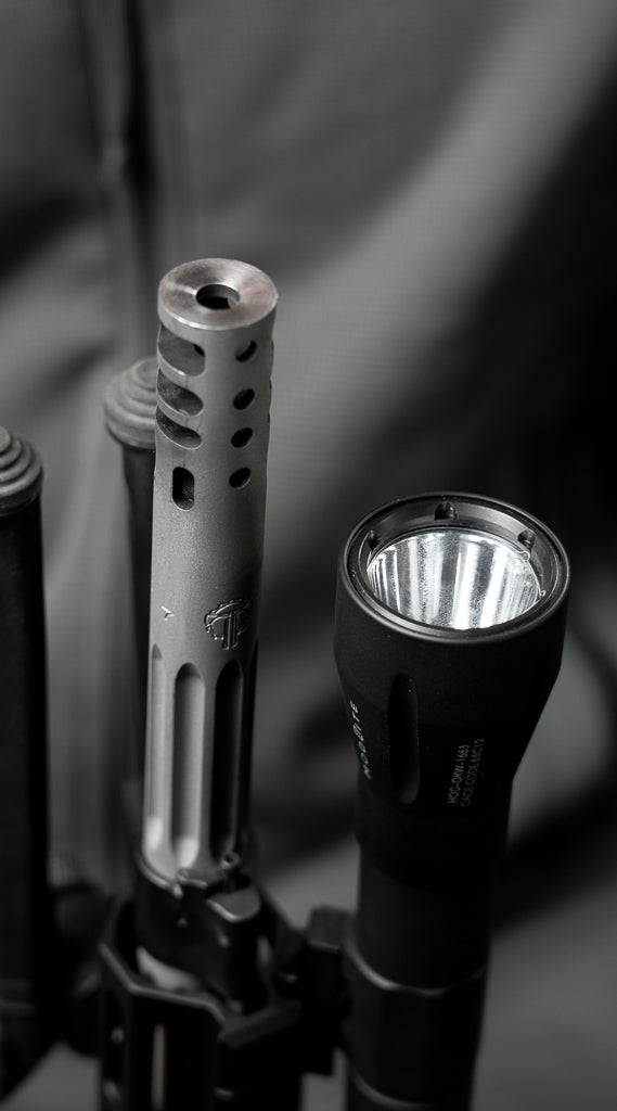 Close-up of a mounted tactical flashlight and a suppressor
