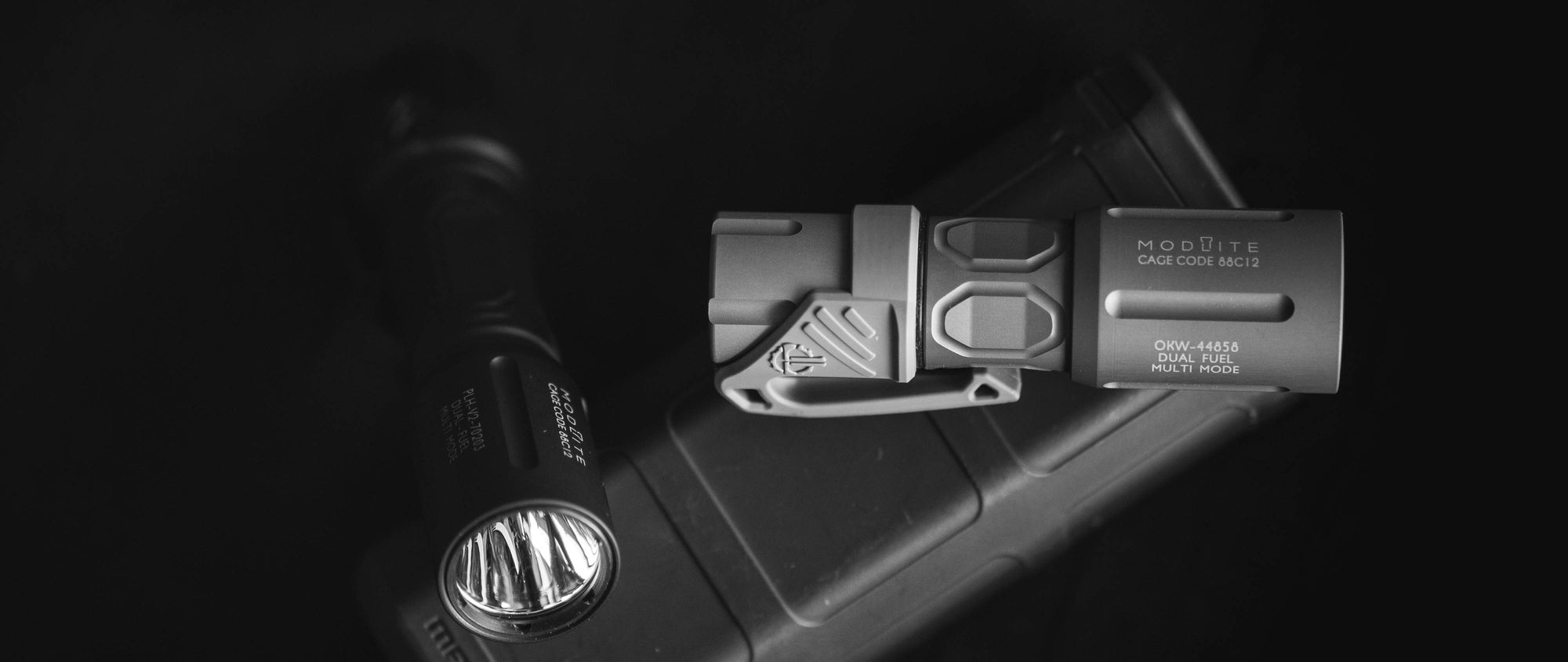 Black and white image of Modlite flashlights with a Thyrm LPC attached