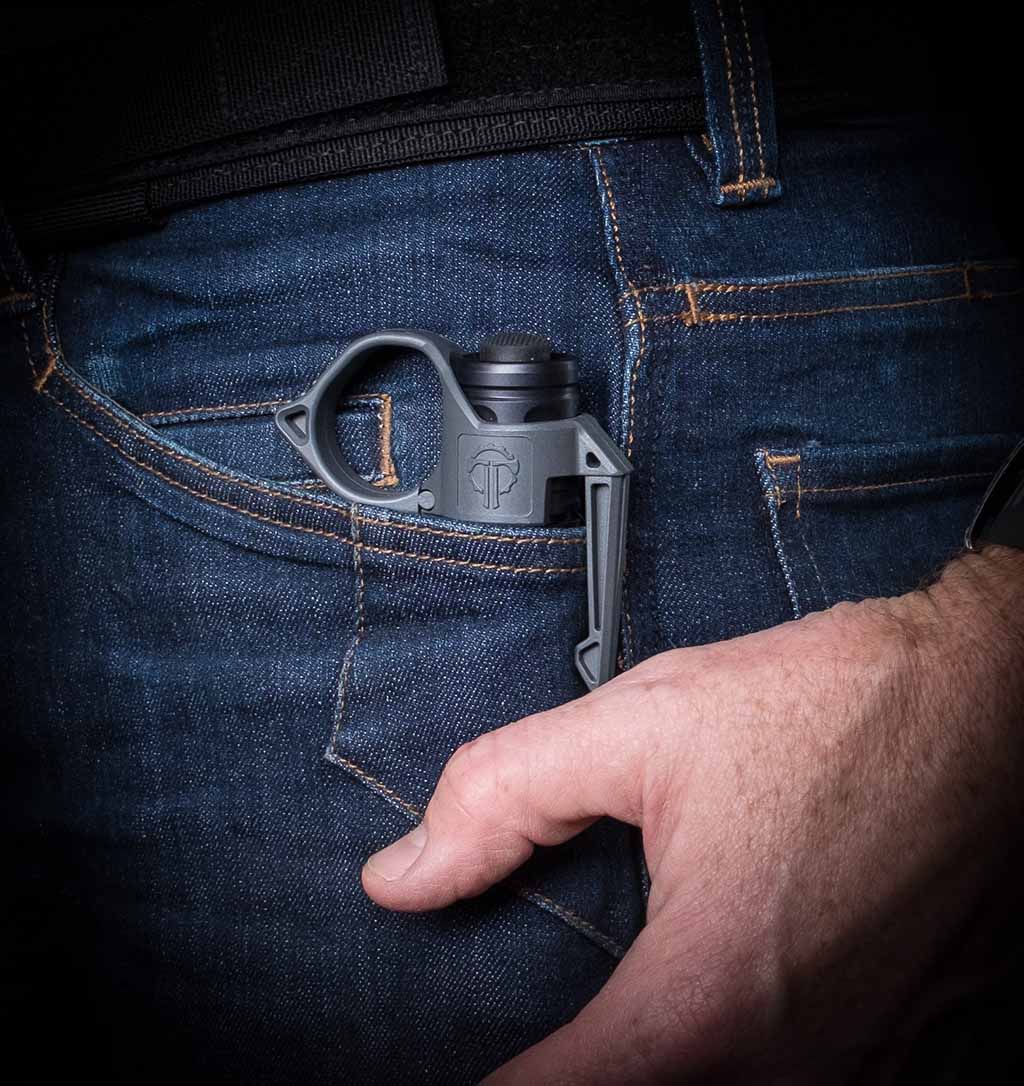 Surefire flashlight with a Thyrm SwitchBack resting in the pocket of jeans