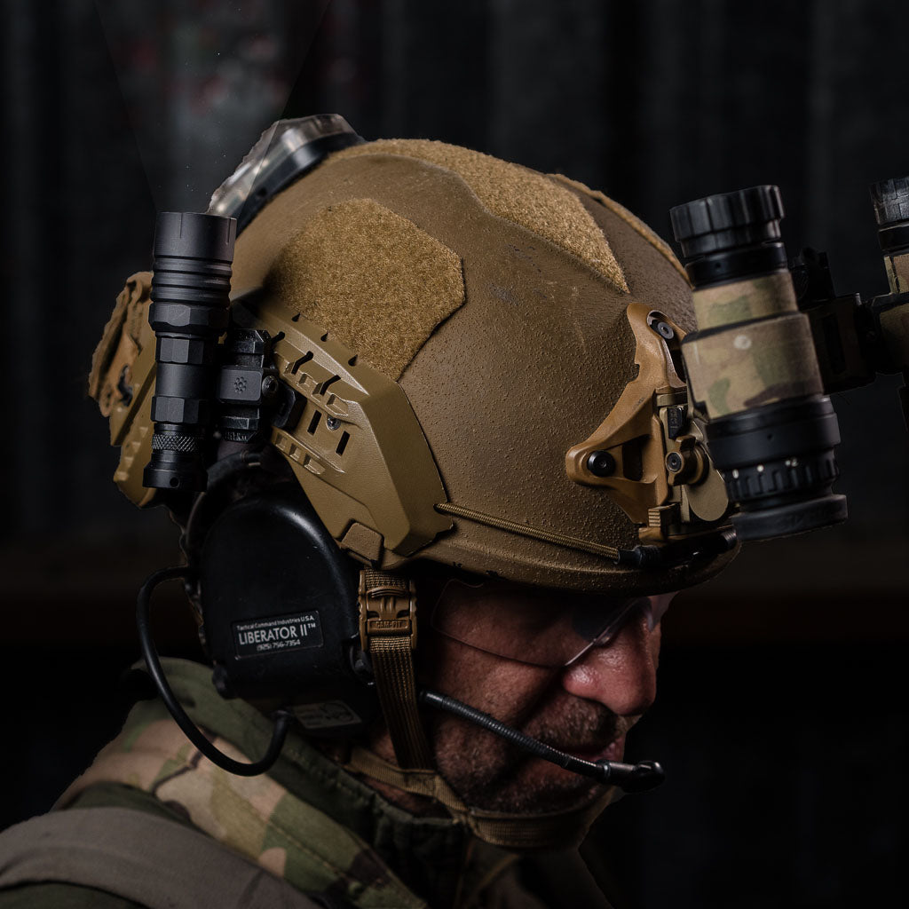 Person wearing a tactical helmet with communication equipment, Thyrm VariArc Helmet Light Mount, and NODs.
