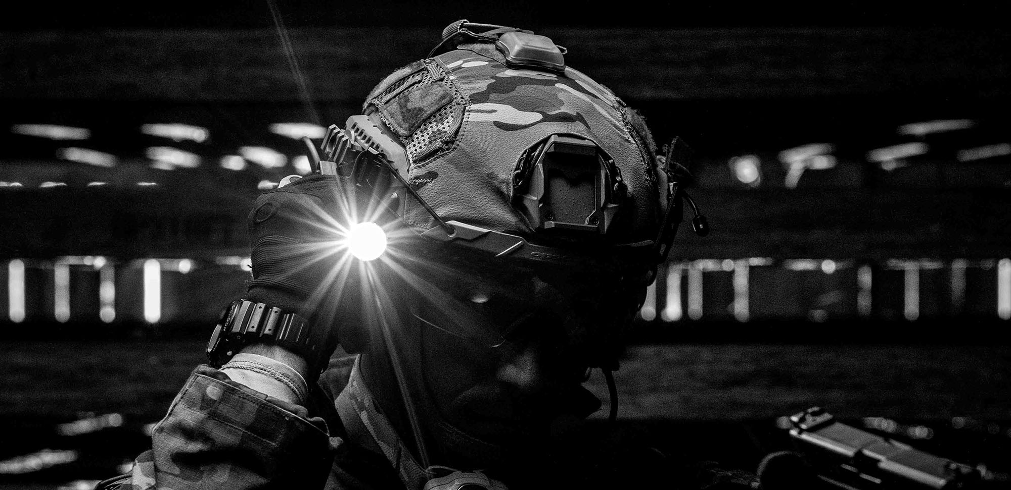 Person illuminating a dark building with a Thyrm SwitchBack on a flashlight