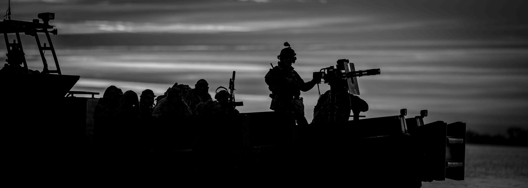 Silhouette of a military squad on a boat against a dark sky