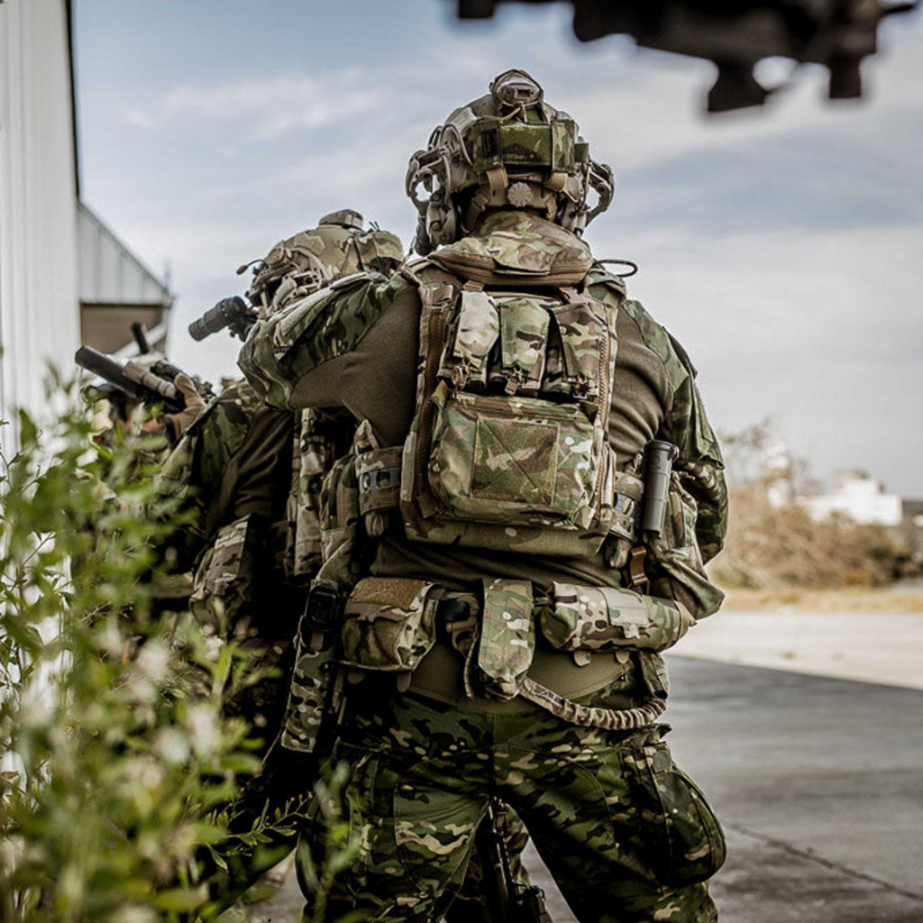 Soldiers walking down a street.  One wears a CellVault Battery Storage Case on the back of his duty vest.