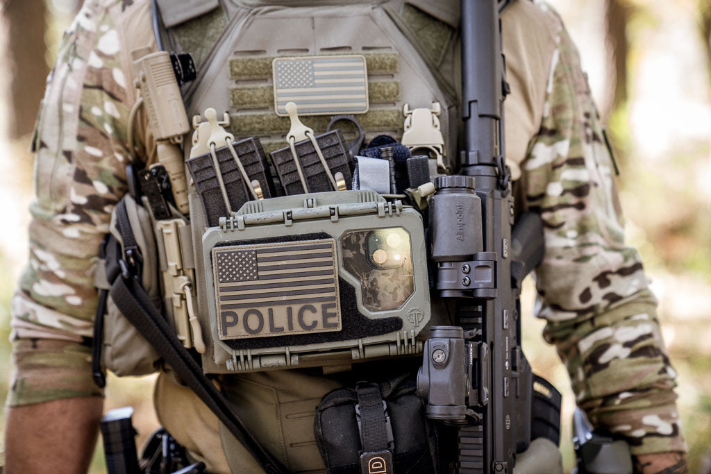 Person in tactical gear with a a DarkVault Comms 2.0 Case with a phone visible inside