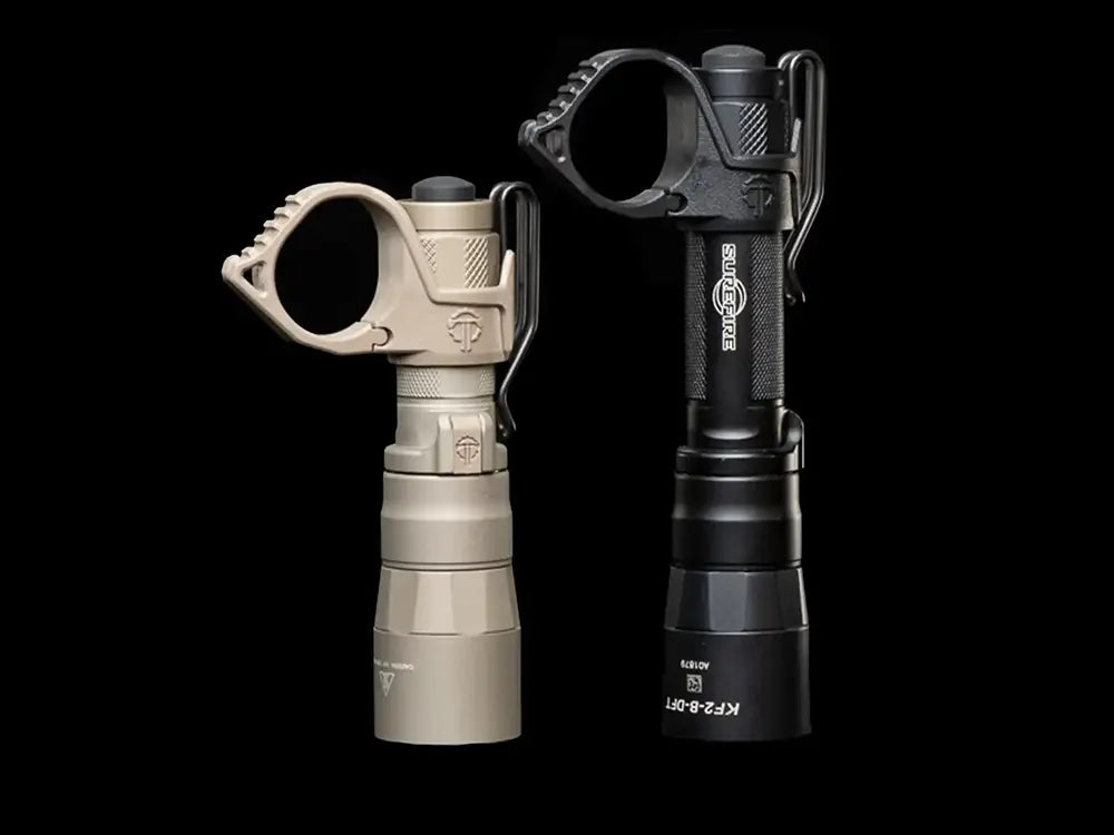 Two tactical Surefire flashlights, one FDE and one black, with Thyrm SwitchBacks.