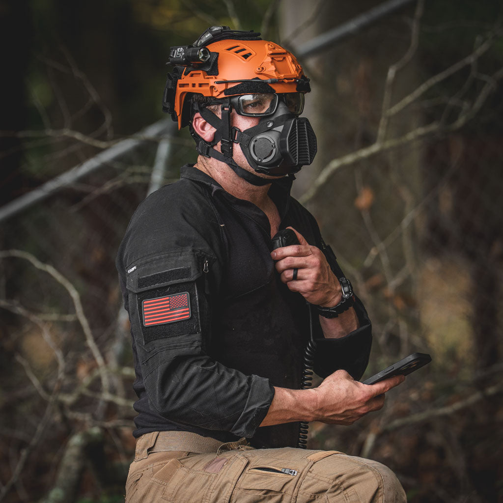 Search and rescue worker with an orange helmet with a Thyrm VariArc attached