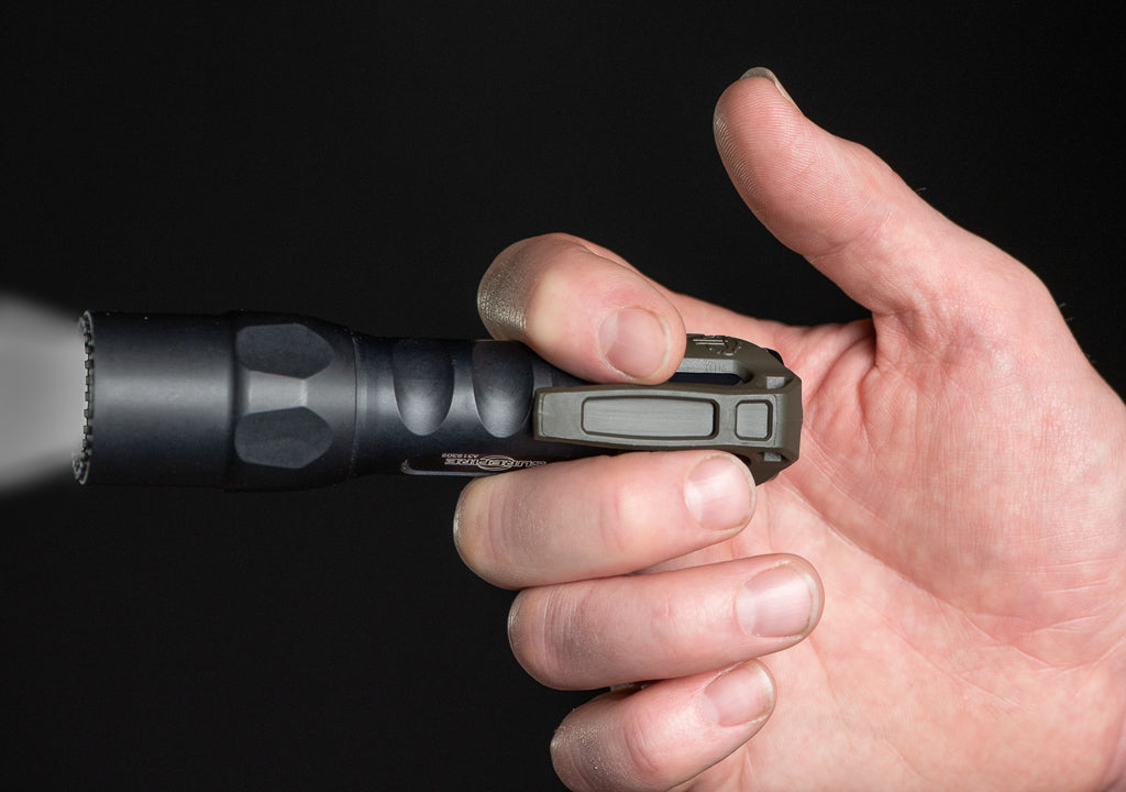 Close-up of a person's hand holding a tactical flashlight with a Thyrm LPC.