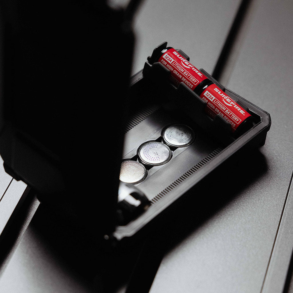 Wells in the base of the CellVault-5M Case hold coin batteries. Modular inserts notch into place above them; the image shows an insert with CR123s lifted out of place.