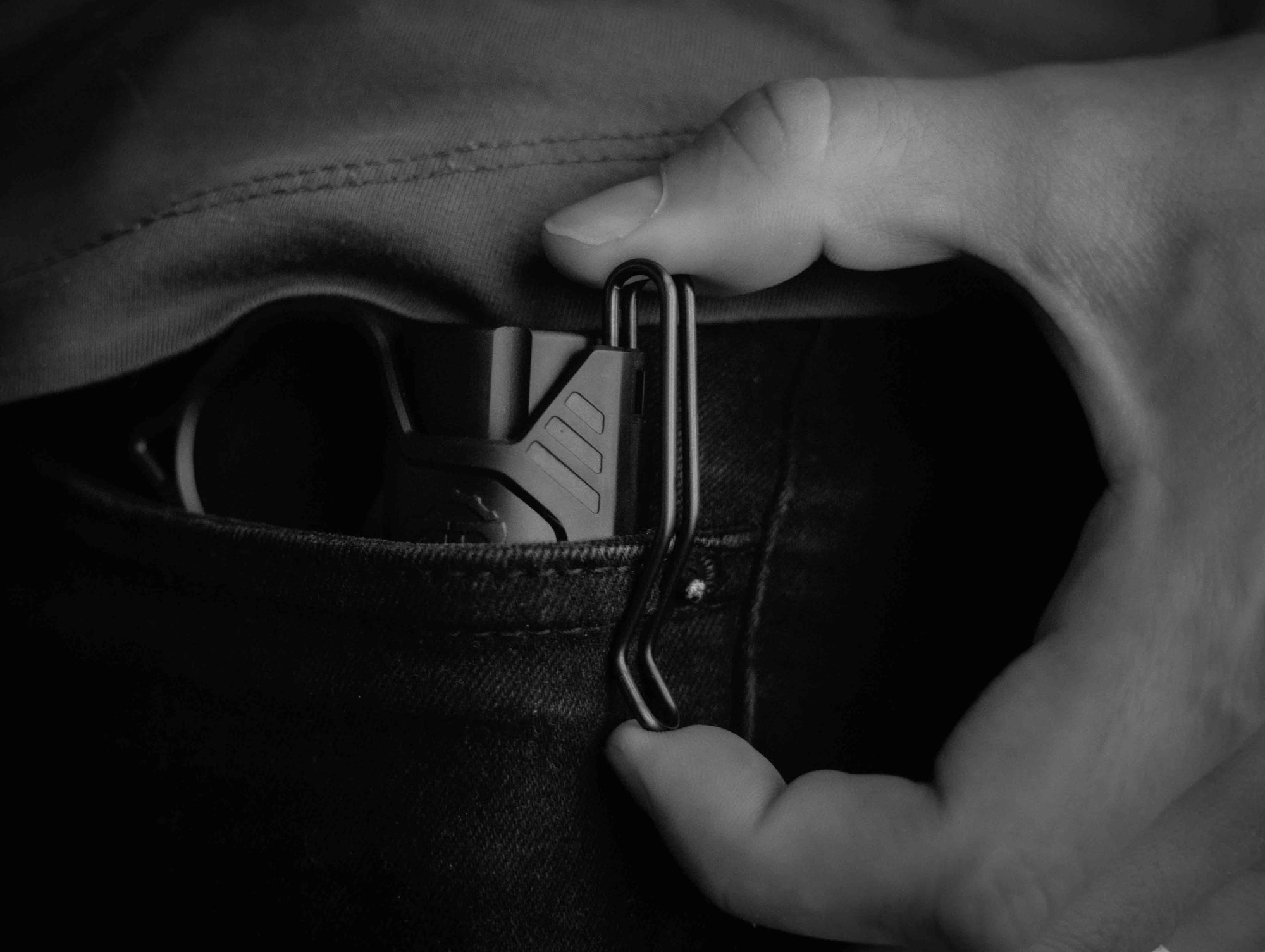 Modlite flashlight in a pocket with a Thyrm SwitchBack 3.0 Deep Carry attached to it.
