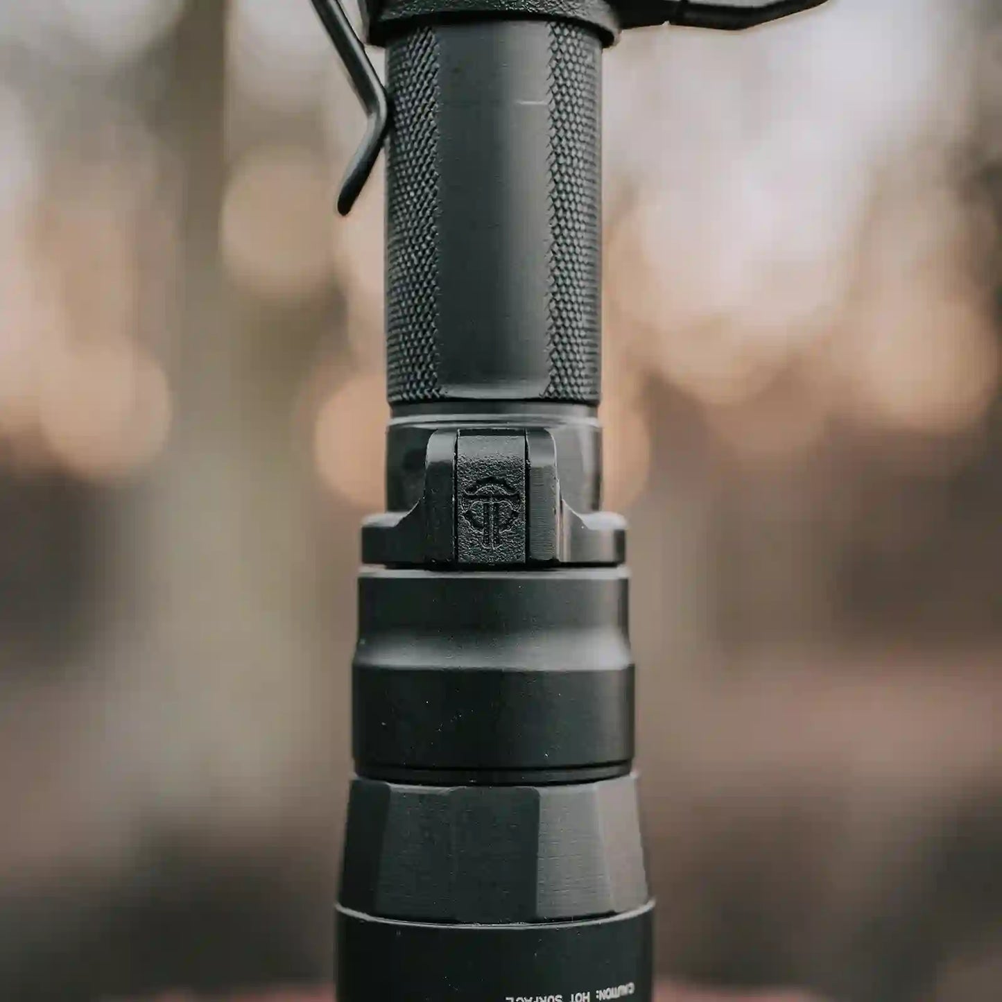 Close-up of a Surefire flashlight showing the Thyrm pocket clip plug.