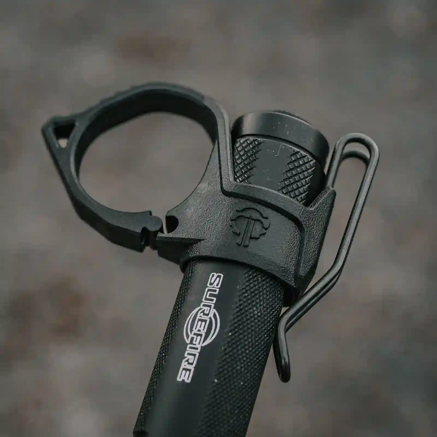 Close-up of a Surefire flashlight and a Thyrm Switchback with the breakaway finger ring. 