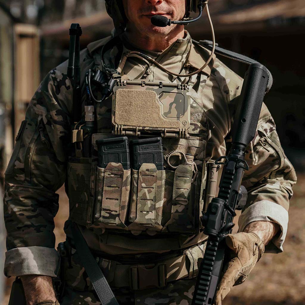 Soldier in full tactical gear, wearing a tactical vest with a Thyrm DarkVault 2.0 and a Thyrm CellVault Battery Storage Case