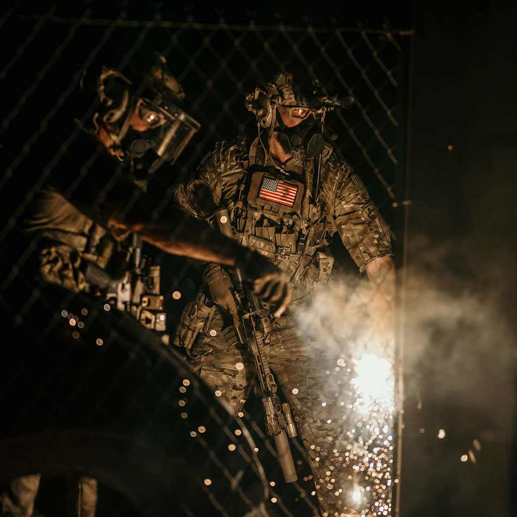 Two soldiers in tactical gear with American flags on a dark background