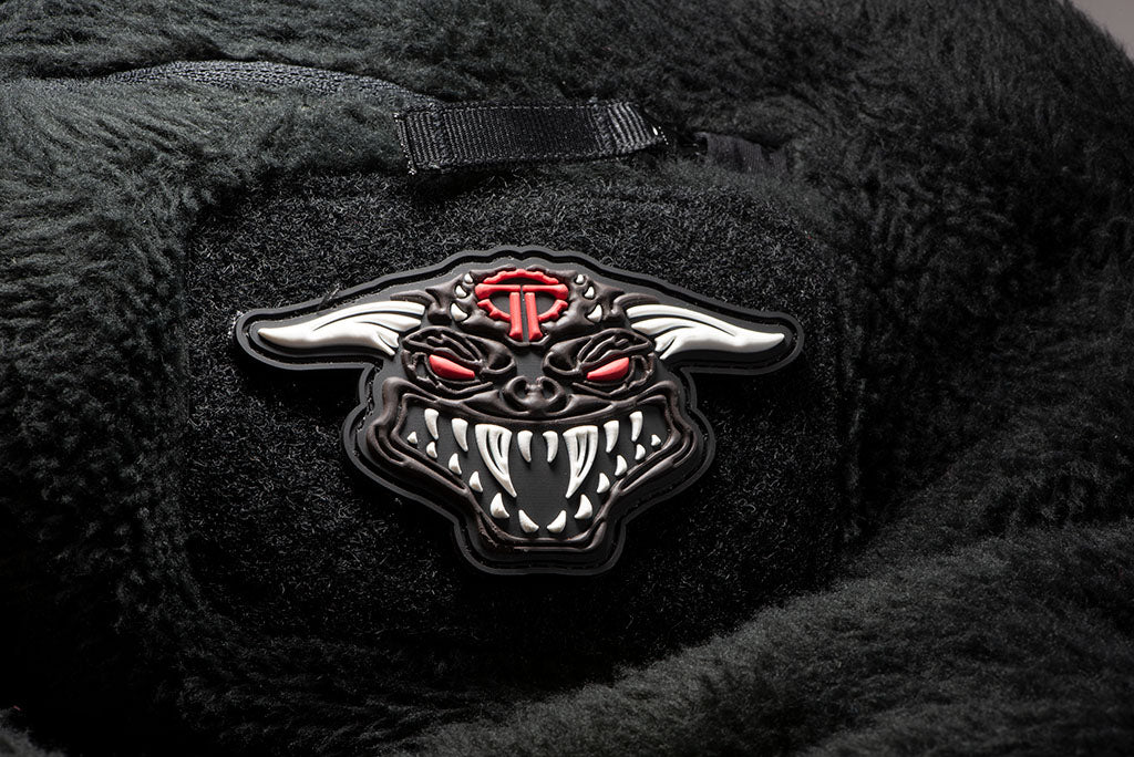Black plush jacket with a Thyrm Keymaster patch attached to the sleeve