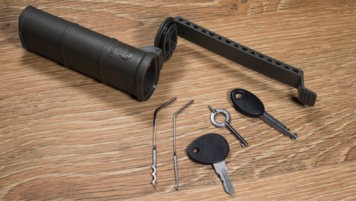 Open CellVault XL alongside its contents: a lock pick and rake, and three keys