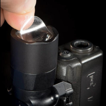 Finger lifting a CLENS Lens Protector off of a weapon light
