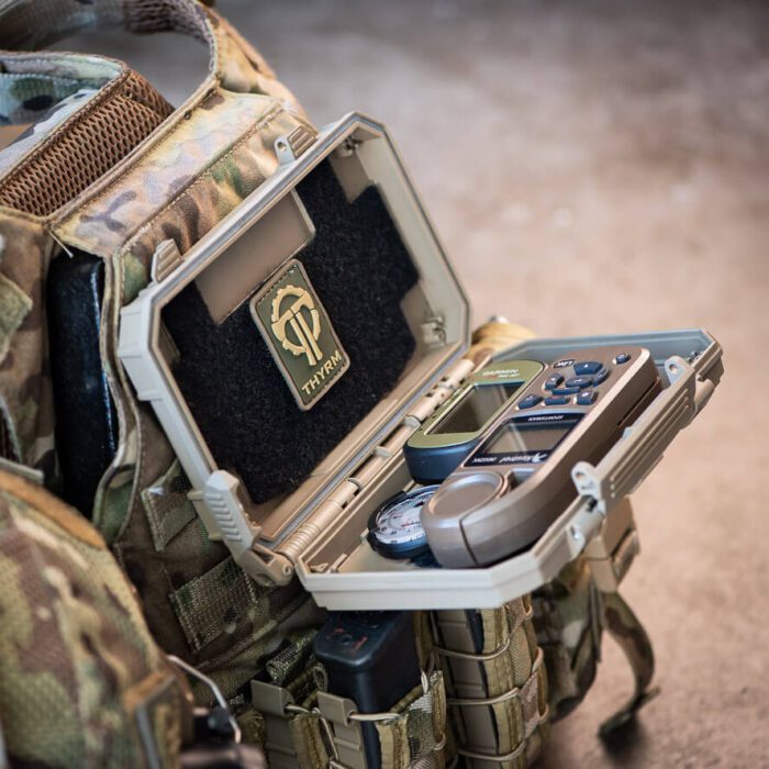 DarkVault Critical Gear Case mounted to a chest rig and holding a patch, GPS, communication, and navigation equipment