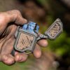 Dirty hand holding PyroVault 2.0 Lighter Armor, showing a clean lighter insert inside
