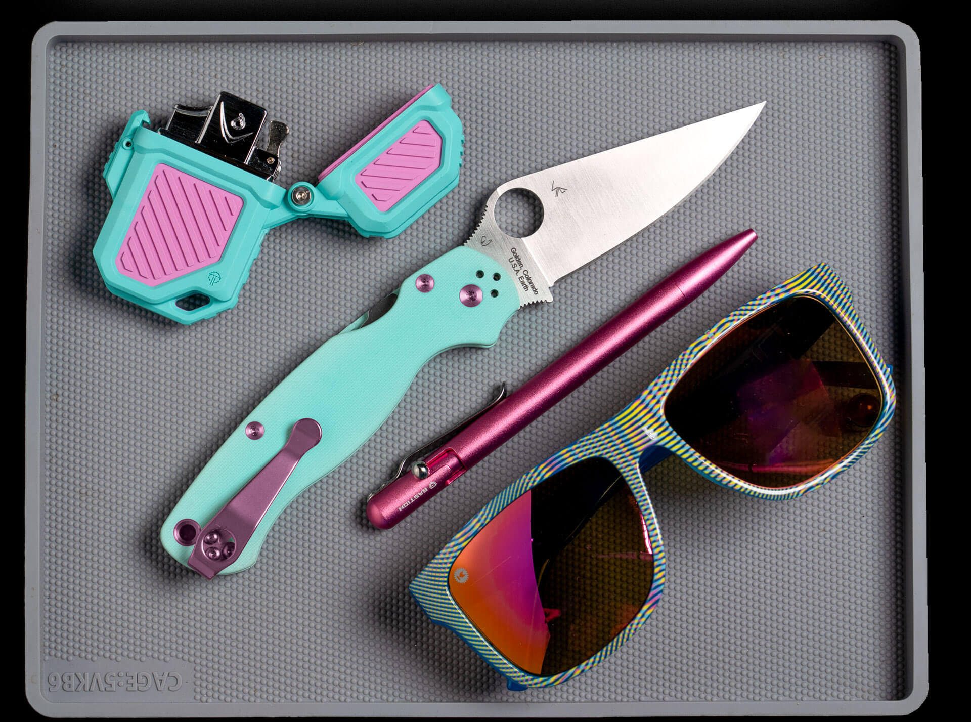 Everyday Carry Layout of PyroVault 2.0 Vice, Knife, Pen, and Sunglasses
